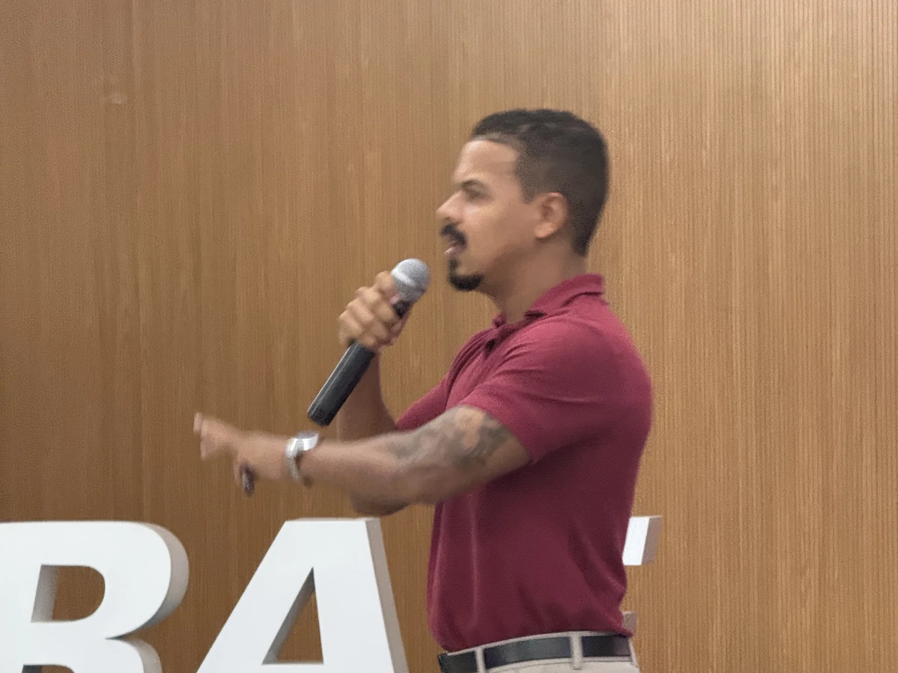 Palestrante falando ao microfone em um palco do Sebrae.