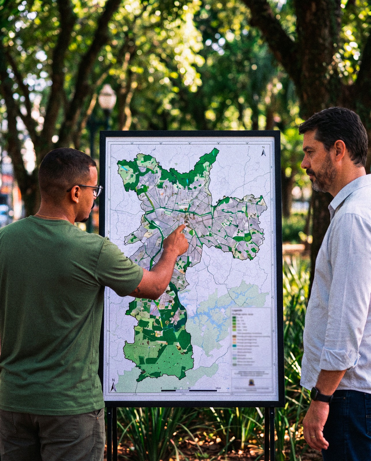 Equipe técnica e gestor municipal analisam um mapa de arborização urbana