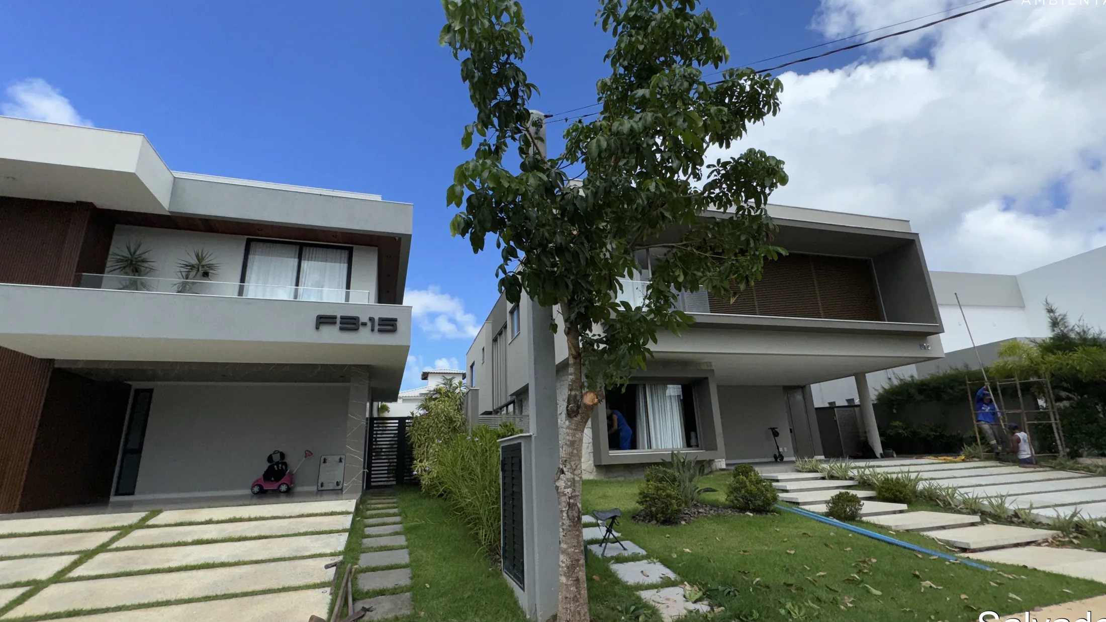 Casa contemporânea integrada a um jardim com árvores e gramado